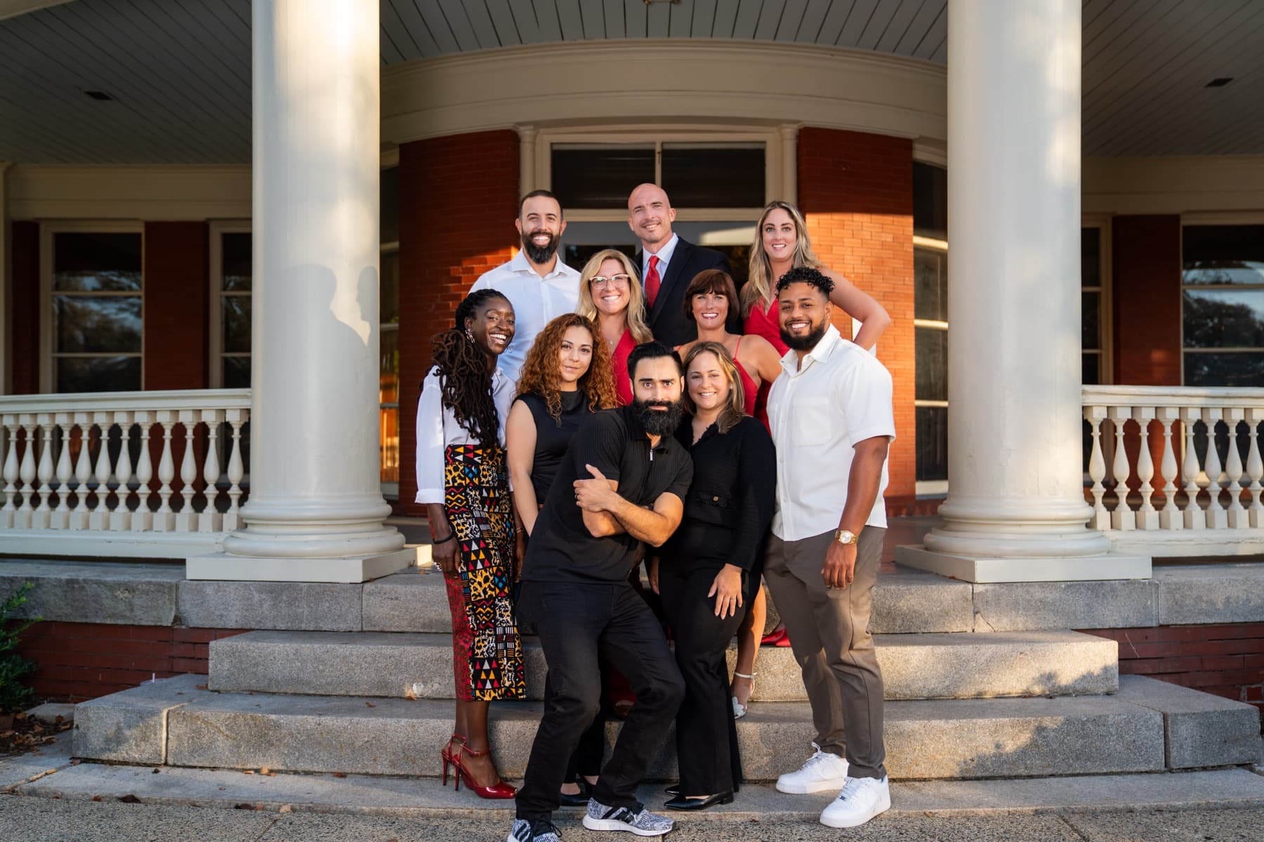 The Here Realty team together on the porch steps