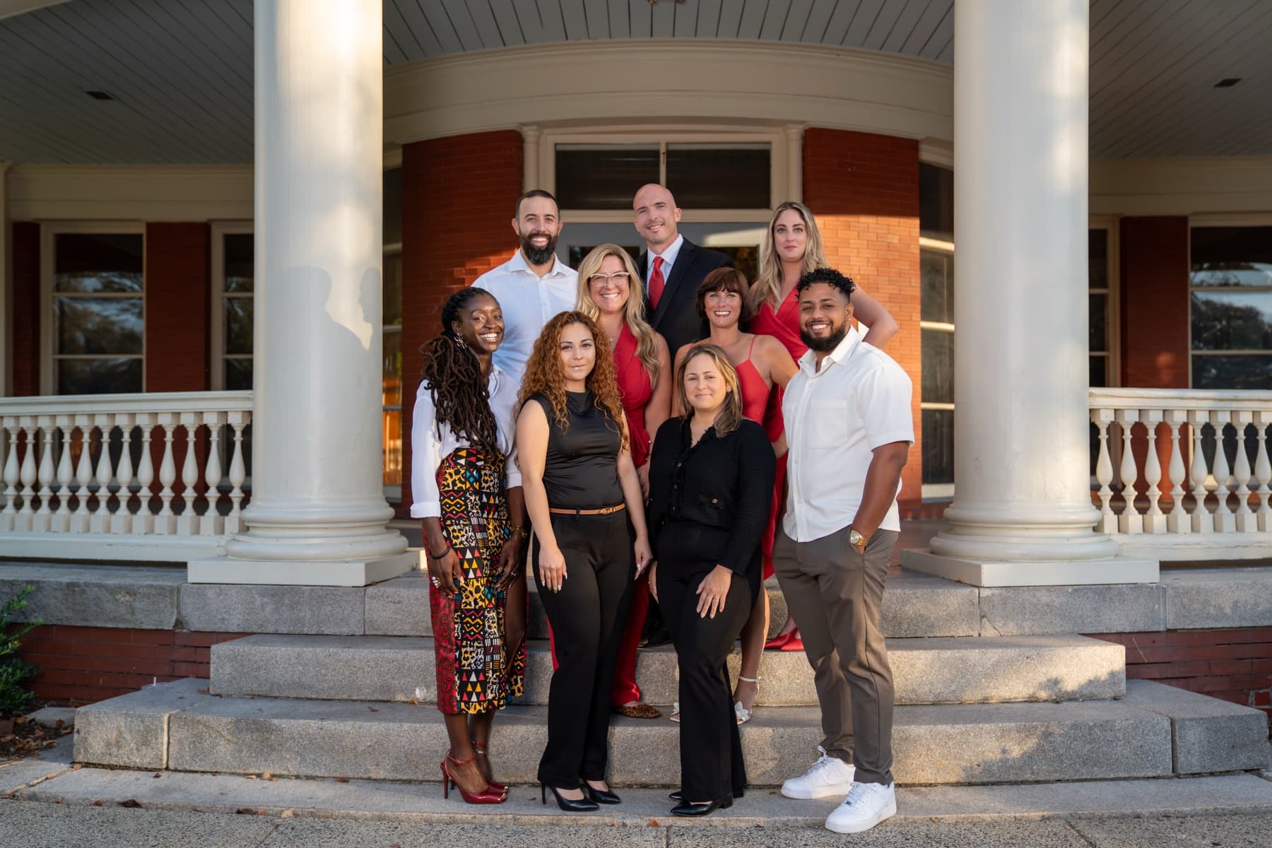 The Here Realty team together on the porch steps